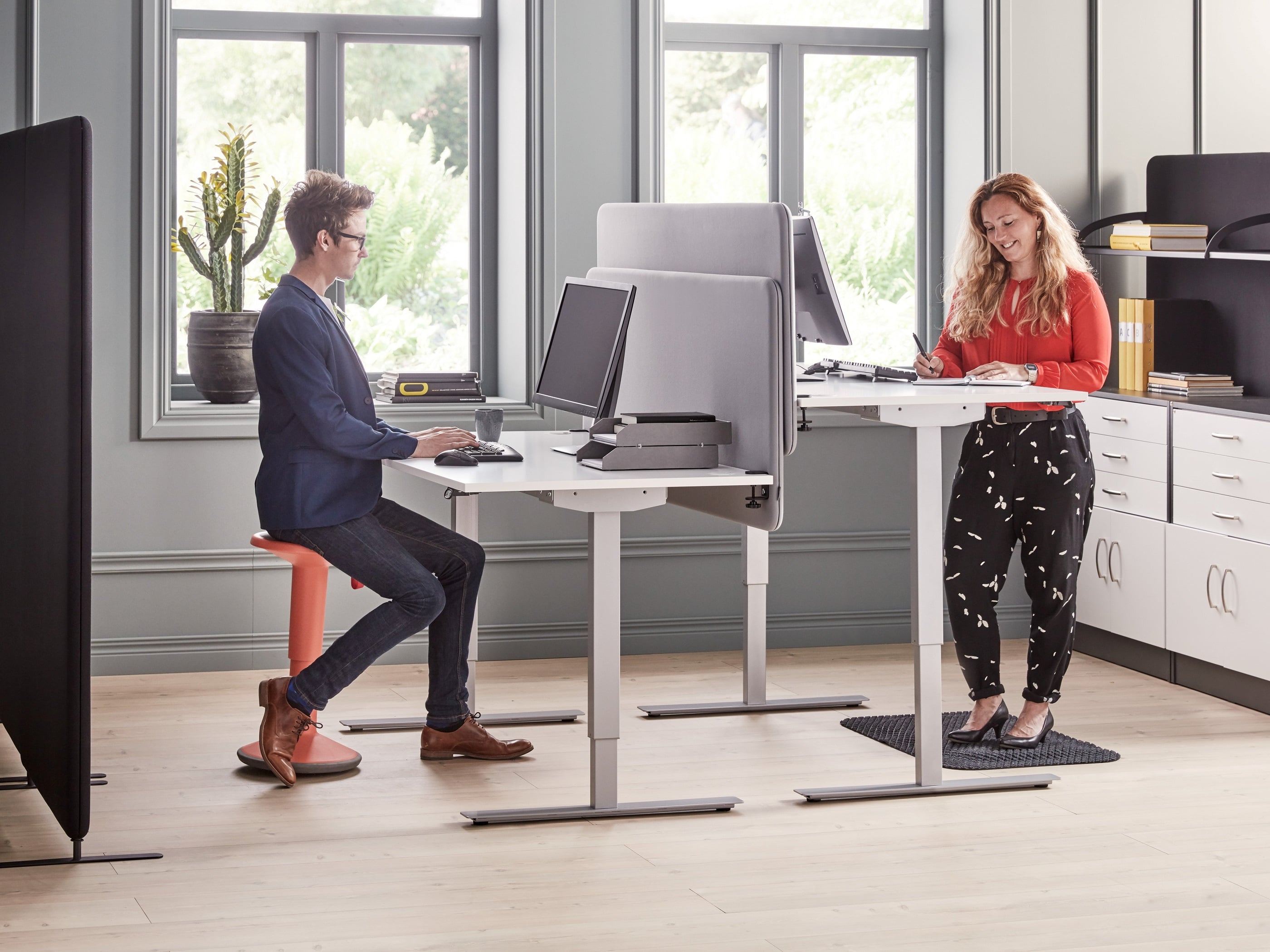 Illustration-style photo of a person shifting between sitting upright and standing at an adjustable desk